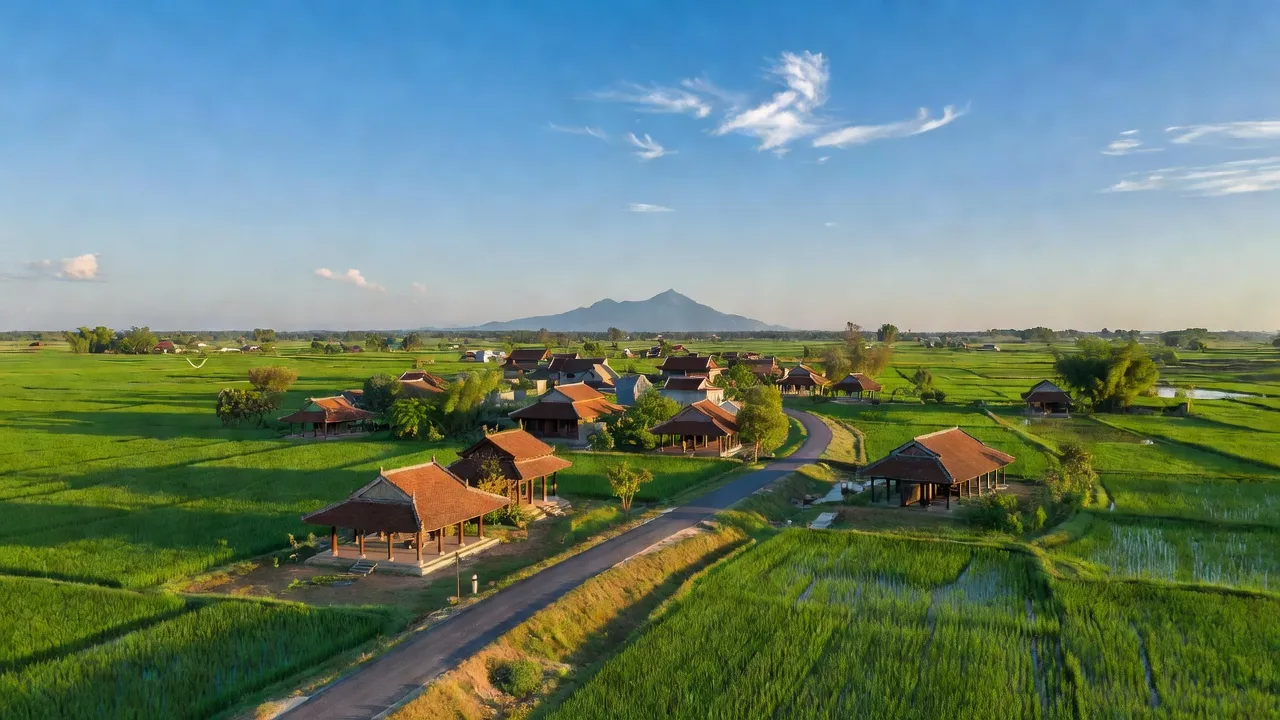 Quang cảnh huyện Gò Dầu, Tây Ninh với cánh đồng xanh, nhà truyền thống và bầu trời trong sáng.